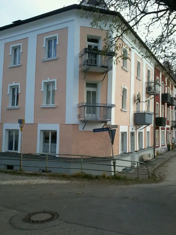 Eckhaus mit apricotfarbener Fassade und weißen Lisenen