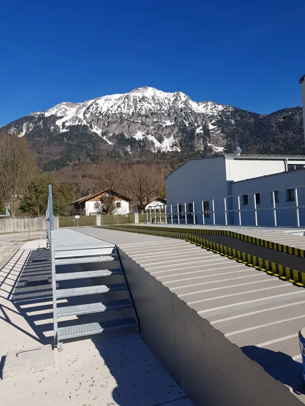 Neu beschichtete Außenanlage mit Treppe vor Bergkulisse