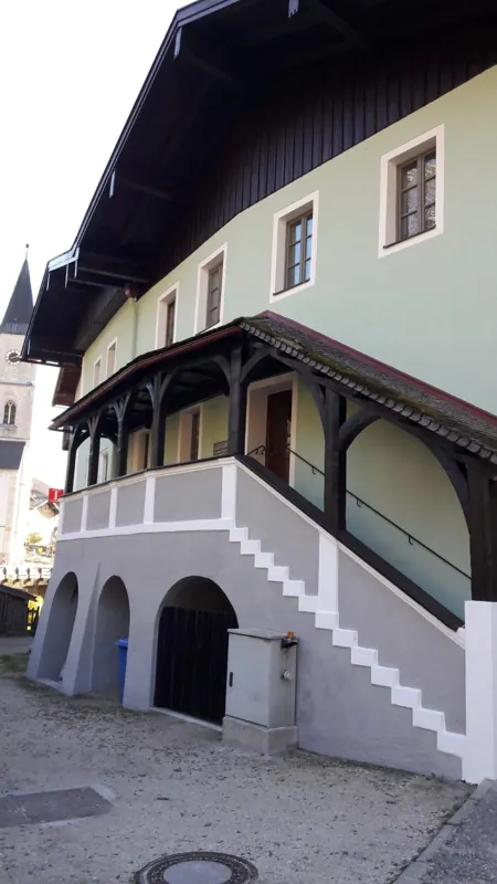 Haus mit hellgrüner Fassade und grau-weiß abgesetzter Außentreppe